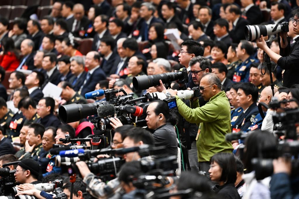 3月8日，十四屆全國人大二次會議在北京人民大會堂舉行第二次全體會議。這是記者在會議現場采訪。新華社記者 牟宇 攝